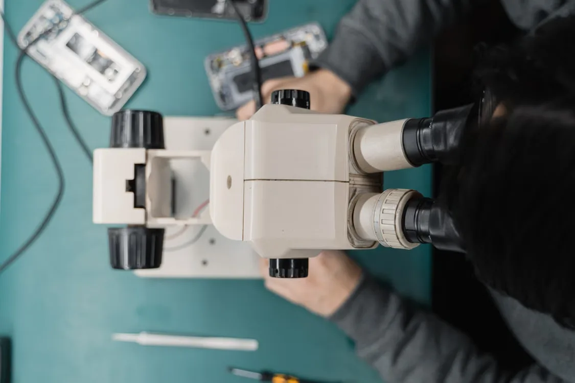 Close-up of a microscope during a precise smartphone repair.